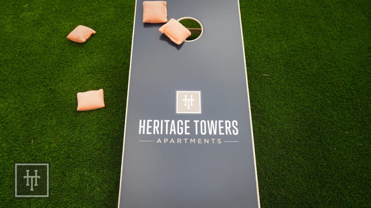 A lawn with cornhole boards and chairs