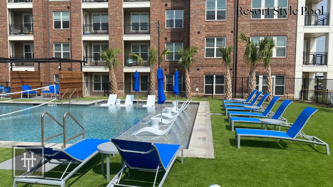 An outdoor pool with lounge chairs and umbrellas