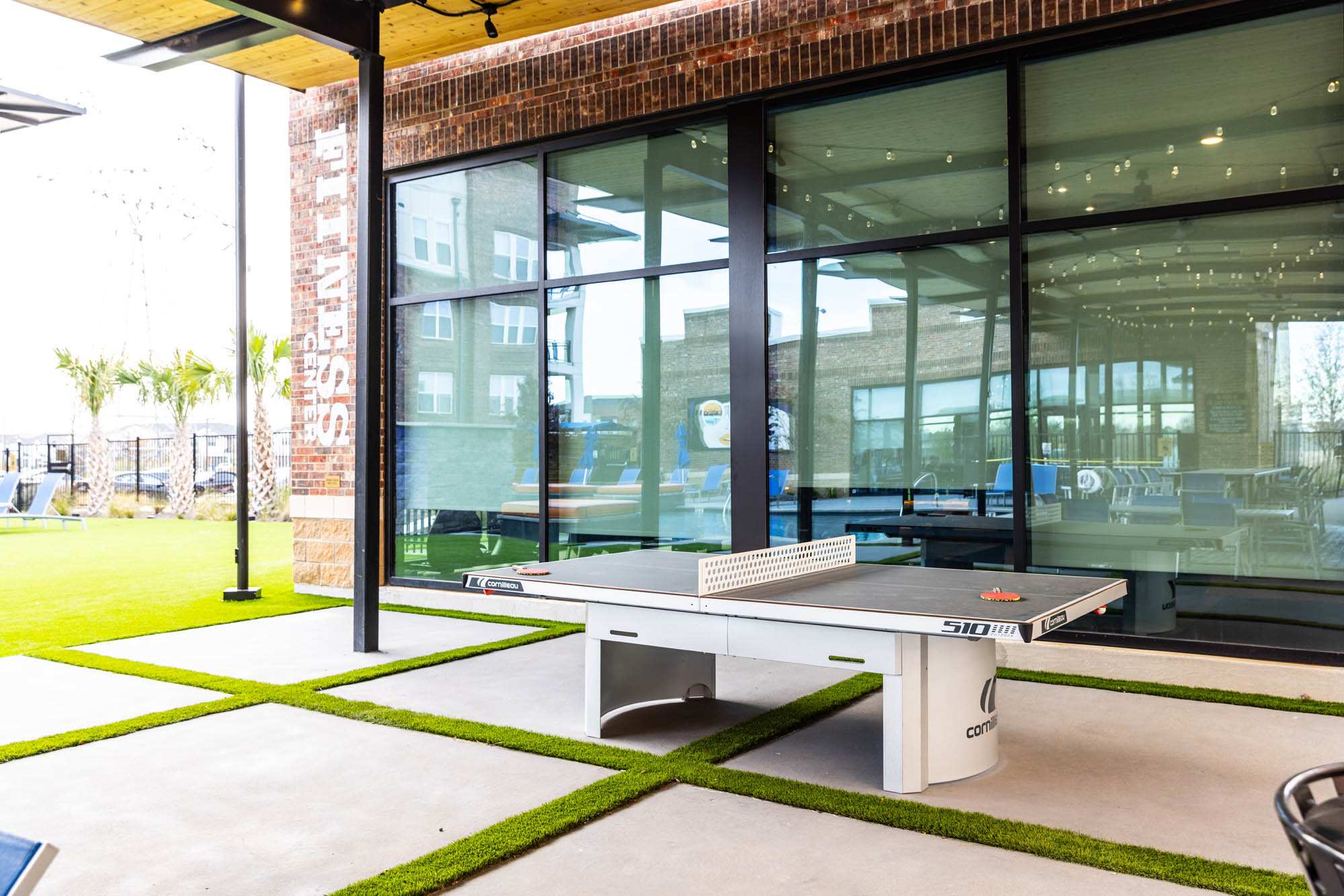 A ping pong table in front of a glass door