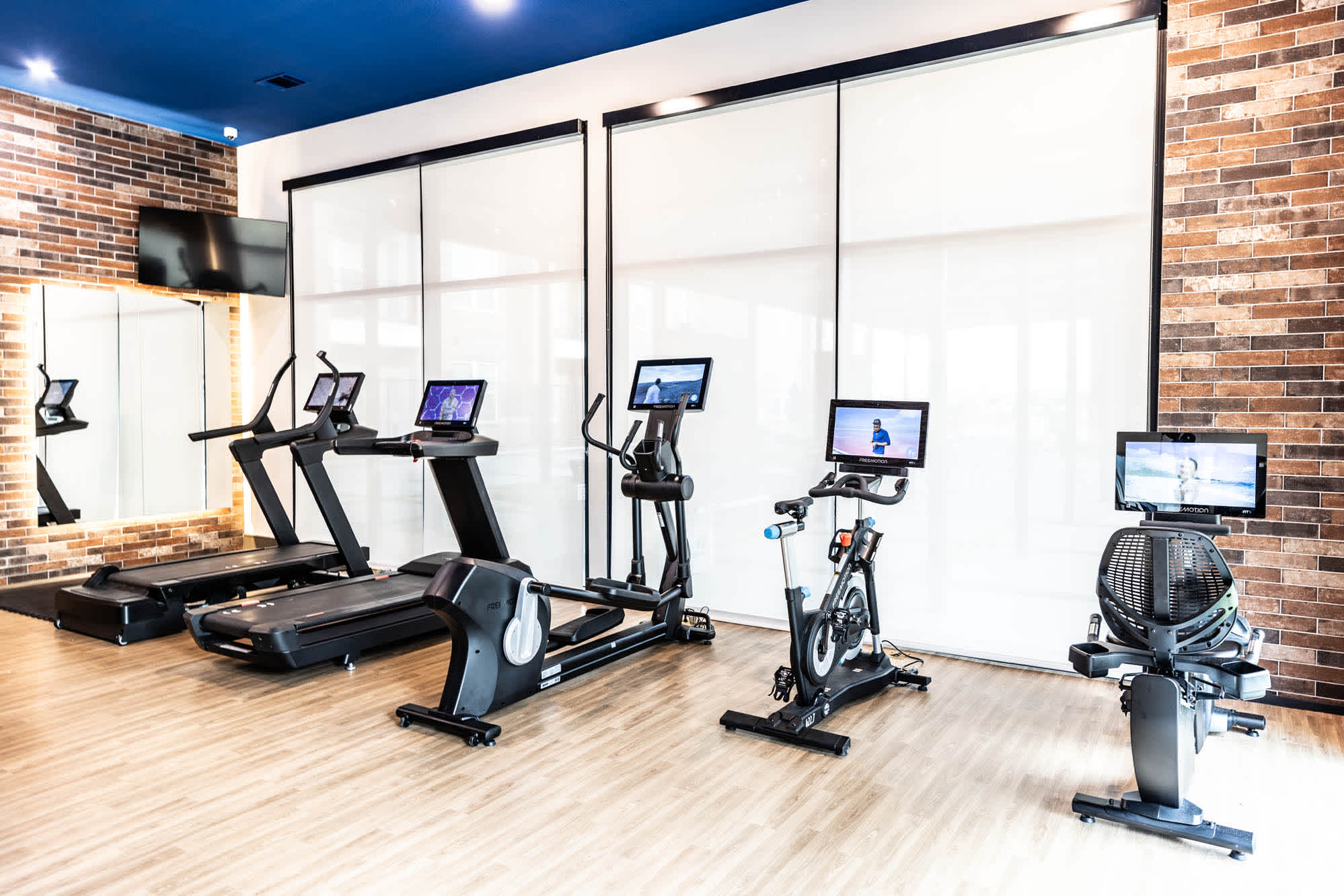 A workout room with treadmills and televisions in a fitness center