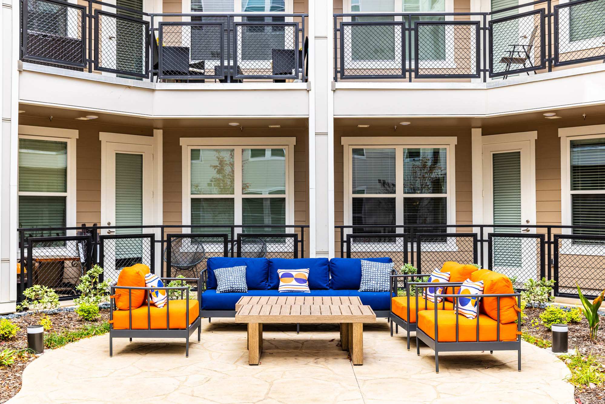 A patio with furniture and a table in front of a building